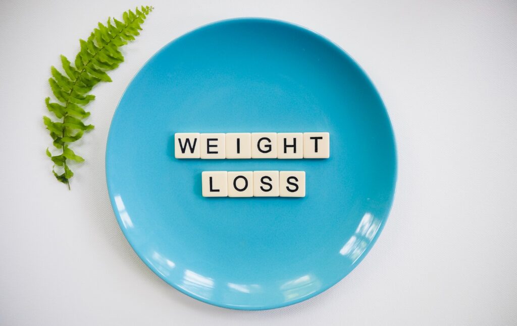 A white plate with the words Weight Loss written wooden blocks.